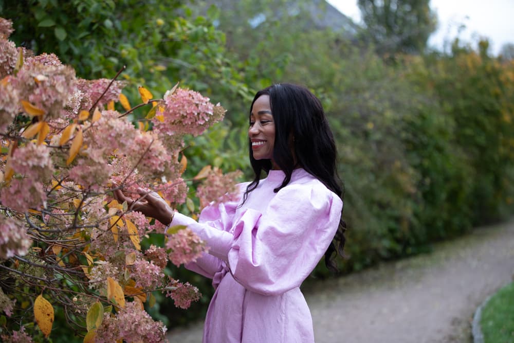 Chisom Udeze beside flowering shrubs